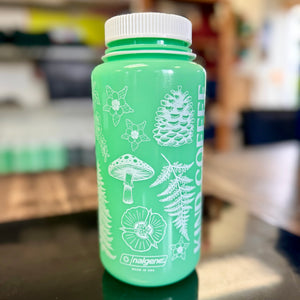 A glow in the dark water bottle with white ink and plants and flowers design